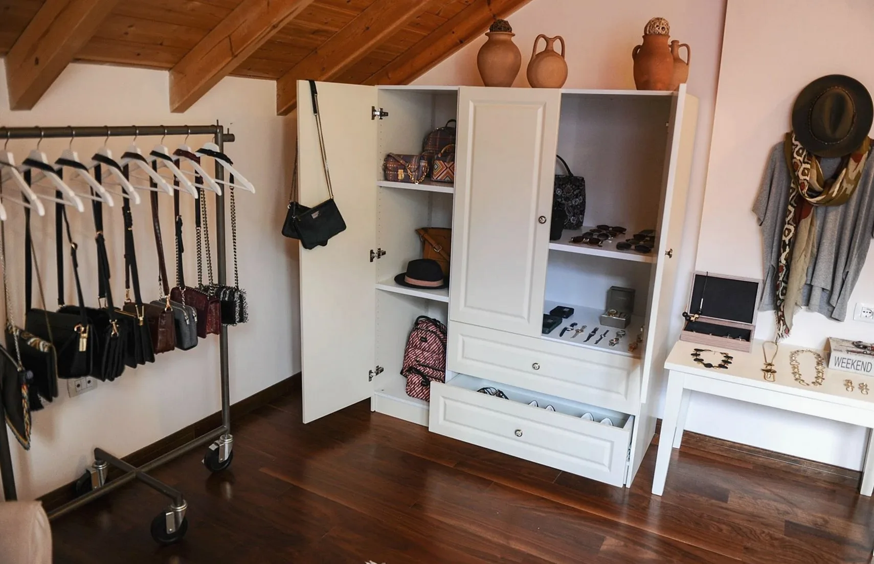 Interior of a modern walk-in closet featuring a variety of accessories and fashion items on display.